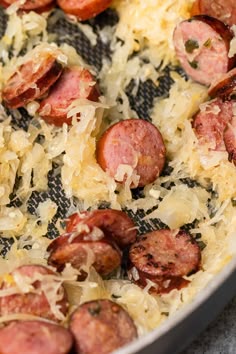 cooked sausages and sauerkraut in a pan with grated parmesan cheese