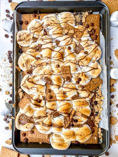 a baking pan filled with baked goods on top of a white tablecloth and chocolate chips