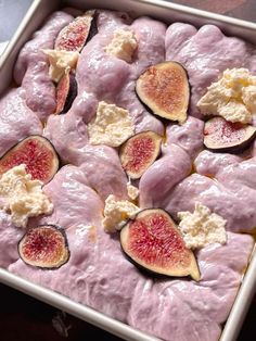 a pan filled with meat covered in cheese and figs