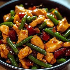 a bowl filled with chicken and green beans