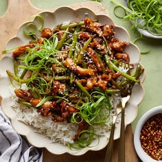 a white plate topped with rice and meat covered in sesame seed garnishments