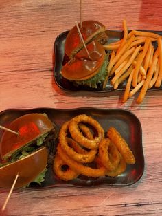 two trays filled with food on top of a wooden table next to each other