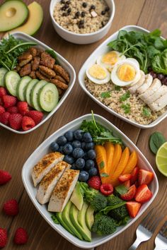 four bowls filled with different types of food on top of a wooden table next to strawberries and avocado
