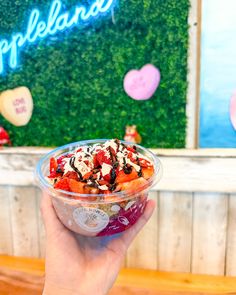 a person holding up a bowl of food