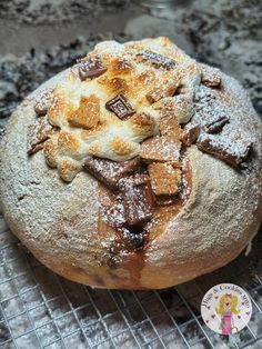 a loaf of bread sitting on top of a cooling rack covered in powdered sugar