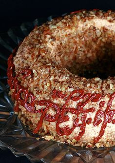there is a cake that has been decorated with red icing and nuts on it
