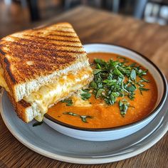 a grilled cheese sandwich with tomato soup on a plate