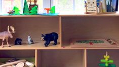 toy animals and other toys on shelves in a playroom