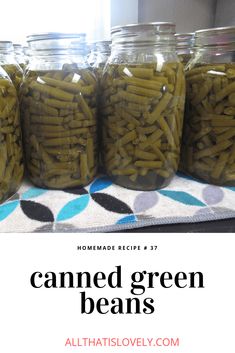 jars filled with green beans sitting on top of a table