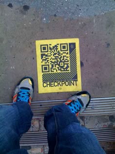 someone is standing next to a yellow check point sticker on the ground with their feet up
