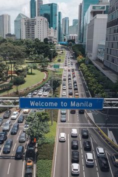 an overhead view of a street with many cars on it and the sign welcome to manila
