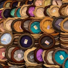 many hats are stacked on top of each other in different colors and sizes for sale