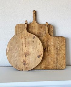 two wooden cutting boards sitting on top of a white counter next to each other,