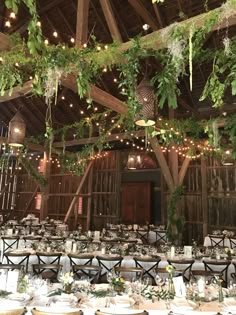 the inside of a barn with tables and chairs set up for an elegant wedding reception