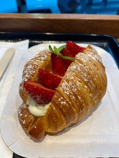 a croissant with strawberries and cream on it
