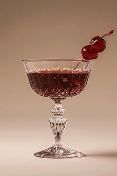 a cherries garnish in a goblet filled with liquid