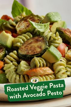 a pasta salad with roasted veggies and pesto is shown on a plate