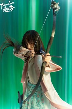 a woman holding a bow and arrow in her hands