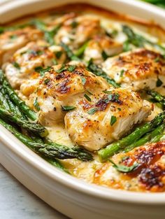 chicken and asparagus casserole in a white dish on a marble surface