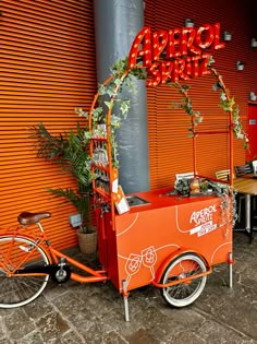 an orange vending cart sitting in front of a building
