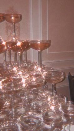 many wine glasses are stacked on top of each other in the middle of a table