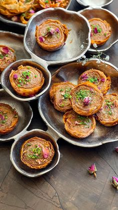 several plates with food on them sitting on a table next to other dishes and utensils