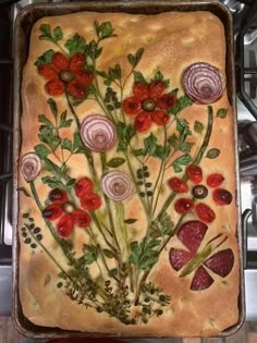 a baking pan filled with food and flowers on top of a stove