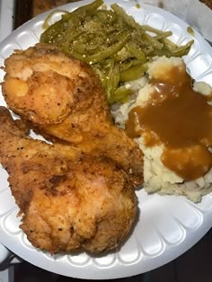 chicken, mashed potatoes and green beans on a paper plate with gravy