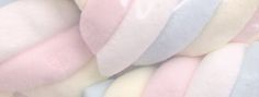 a pile of pastel colored pillows sitting on top of each other