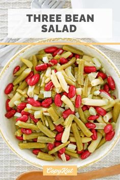 three bean salad in a white bowl with red beans and green beans on the side