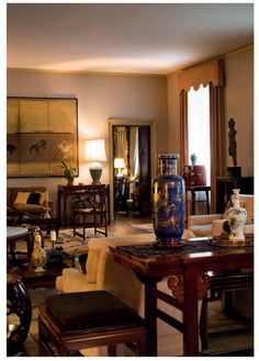a living room filled with furniture and a large vase sitting on top of a table