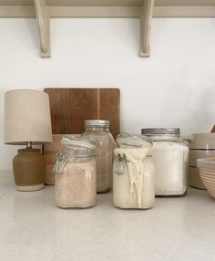 there are many jars and bowls on the counter