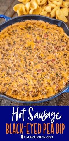 hot sausage black eyed pea dip in a blue casserole dish with chips on the side