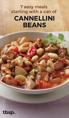 a white bowl filled with beans and meat