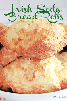 irish soda bread rolls stacked on top of each other in a white bowl with green lettering