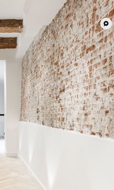 an empty room with brick walls and wood floors