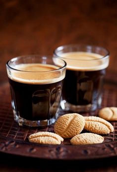 two shot glasses filled with coffee and cookies