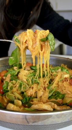 a person is eating some food from a large metal bowl on top of a table