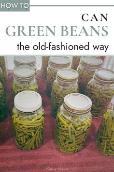jars filled with green beans sitting on top of a red tablecloth covered floor next to each other