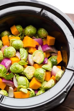 brussel sprouts, carrots and other vegetables are in the slow cooker