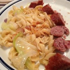 a white plate topped with pasta and meat