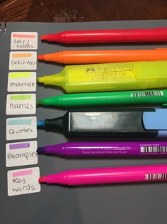 five pens are lined up next to each other on top of a piece of paper