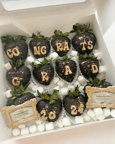 chocolate covered strawberries are arranged in a box with gold letters and numbers on them