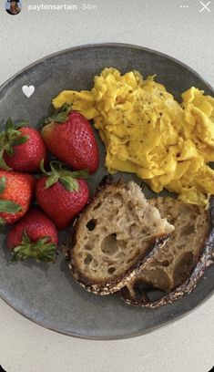 a plate with eggs, toast and strawberries on it