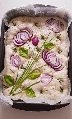 an image of food that is being prepared in a pan on the table with onions and herbs