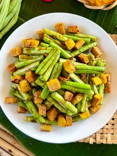 a white plate topped with green beans and tofu