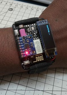 a close up of a person's arm wearing a watch with electronic components on it