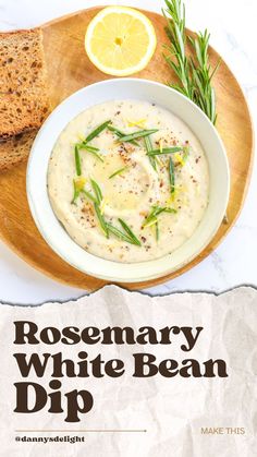 rosemary white bean dip in a bowl with bread and lemon wedges on the side