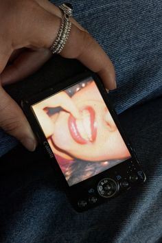 a person holding a cell phone in their left hand and showing an image on the screen