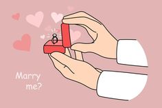 a hand holding a red box with a ring on it and the words marry me?